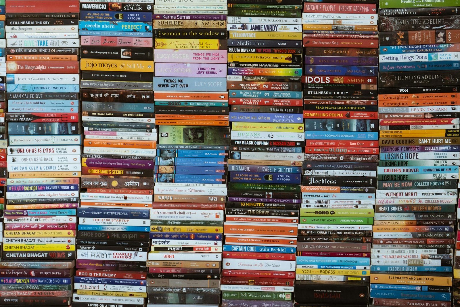 Vibrant collection of books stacked in a Delhi market, showcasing diverse titles and authors.